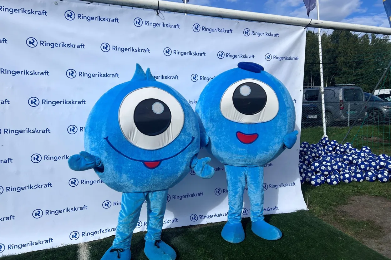 Bilder av Ringerikskrafts maskoter "Sigurd og Saga" foran fotovegg p&aring; fotballbane utend&oslash;rs.&nbsp;